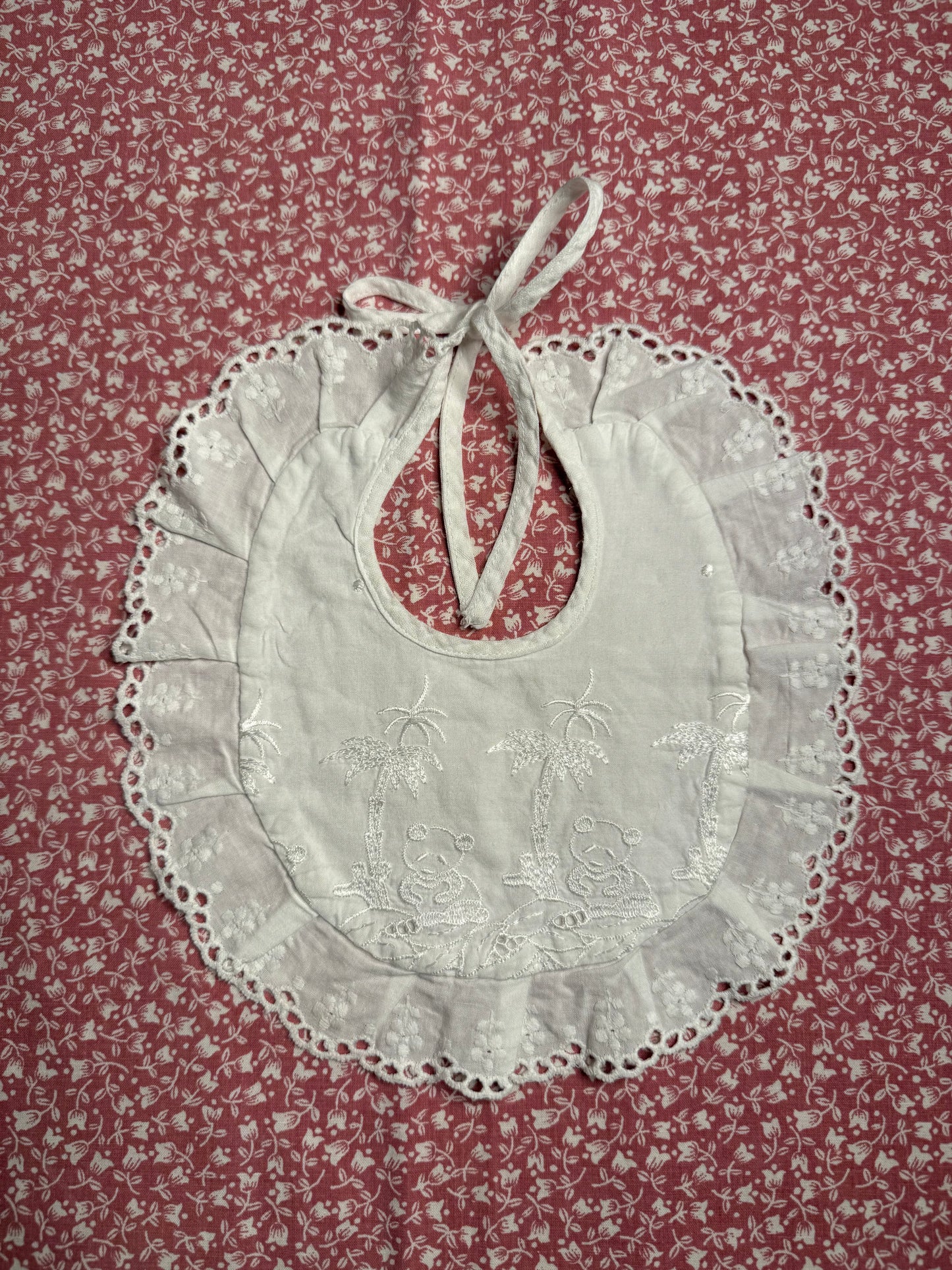 Bavoir ancien de bébé, rond et brodé avec liseré