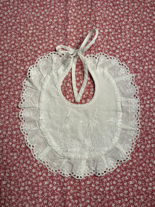Bavoir ancien de bébé, rond et brodé avec liseré