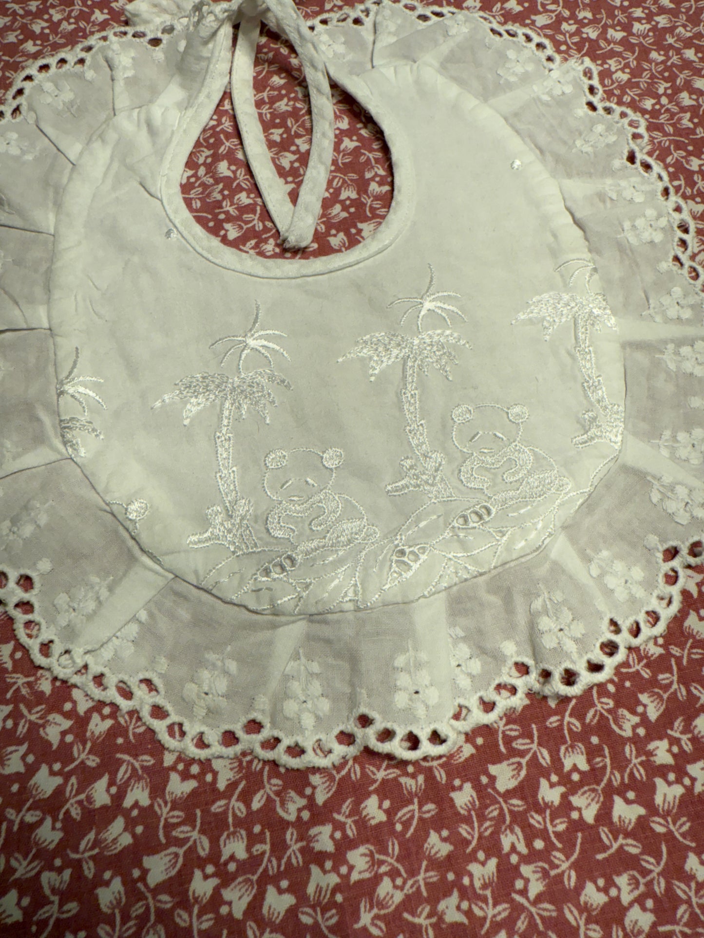 Bavoir ancien de bébé, rond et brodé avec liseré