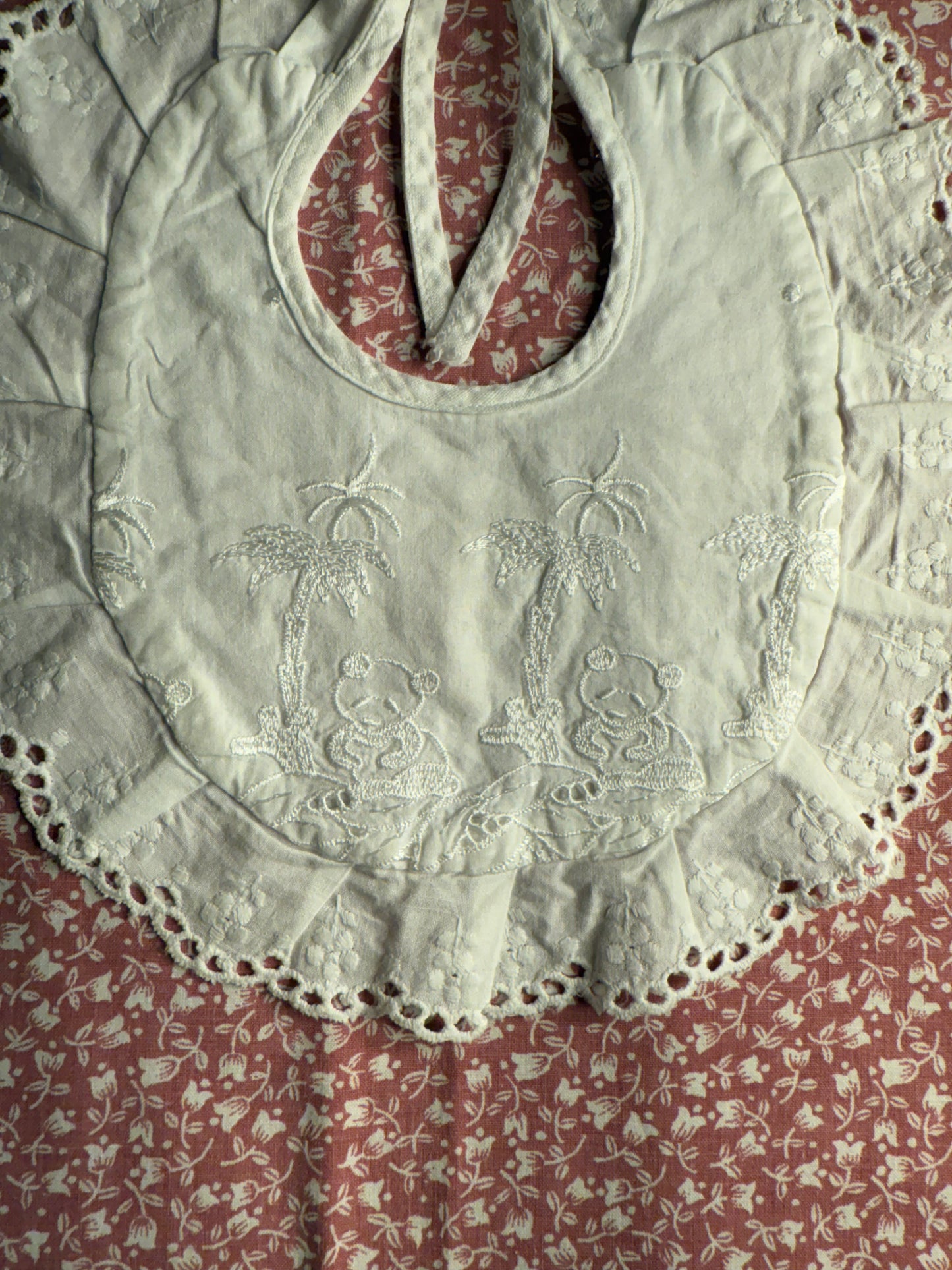 Bavoir ancien de bébé, rond et brodé avec liseré